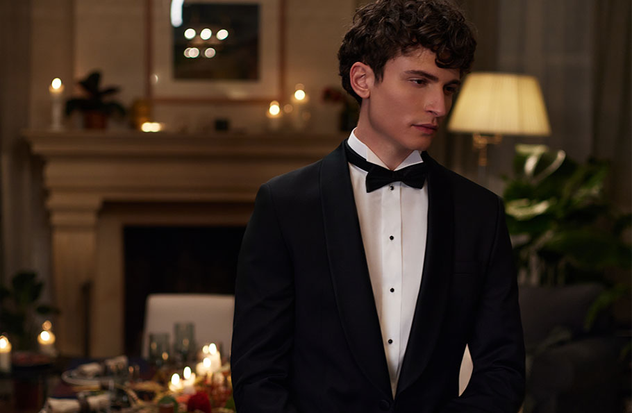 Młody mężczyzna w czarnej marynarce Bytom w trakcie świątecznej kolacji.