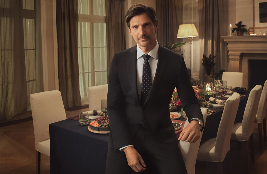 Mężczyzna w eleganckim, czarnym garniturze Bytom podczas świątecznej kolacji.