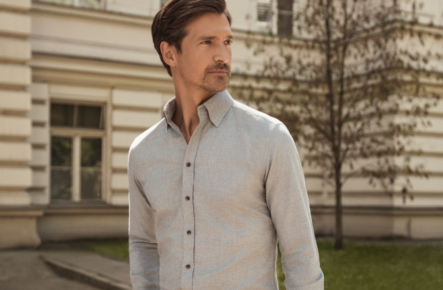 Mężczyzna w szarej koszuli Bytom, w tle zabytkowy budynek.